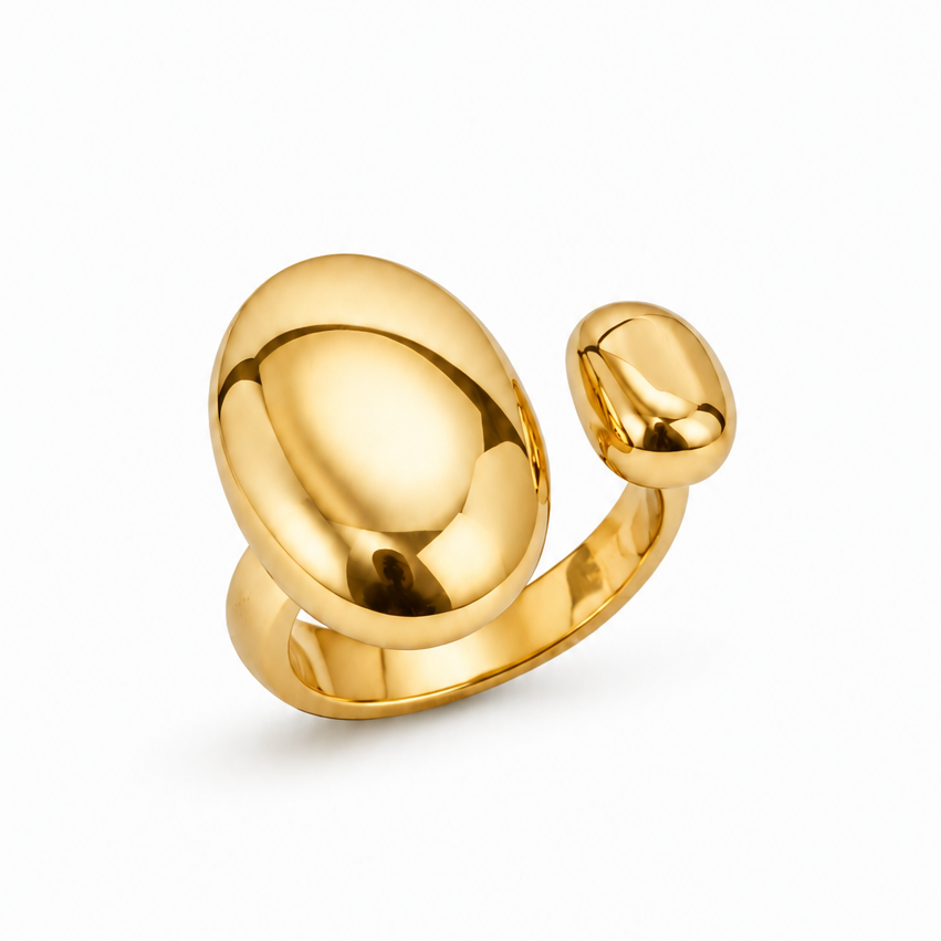 A polished gold-toned ring with a large rounded dome-like top and a smaller rounded protrusion, photographed on a clean white background.