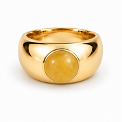 A polished yellow gold ring with a large, smooth oval yellow stone set in the center, shown on a clean white background.